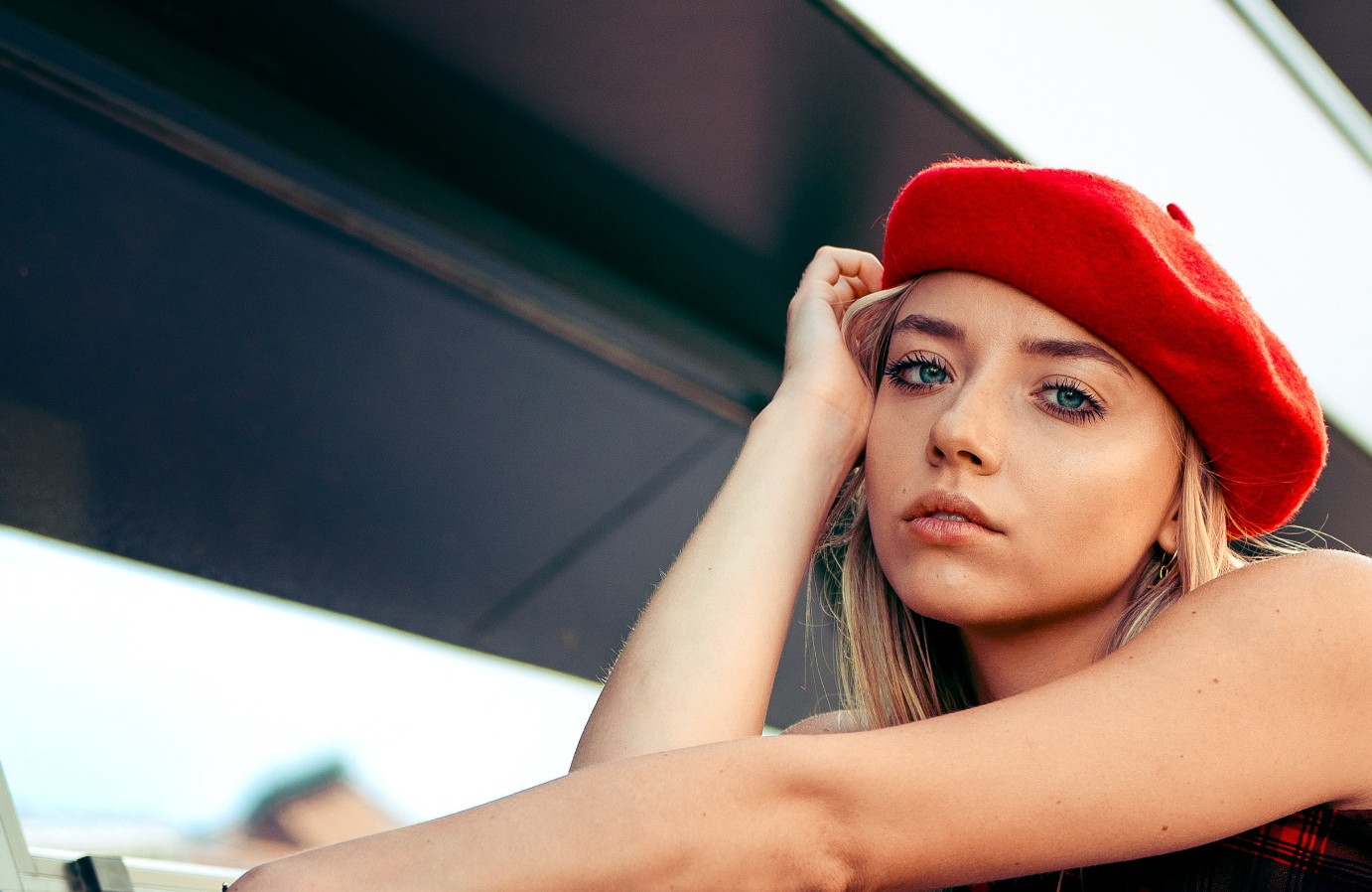 Modelka w czerwonym berecie podczas plenerowej sesji modowej