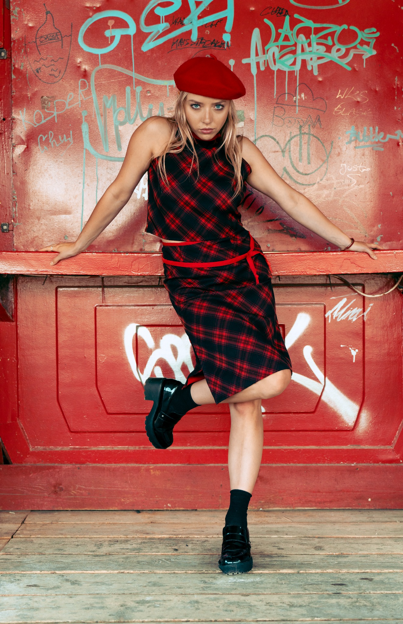 Modelka w czerwonym berecie na tle graffiti