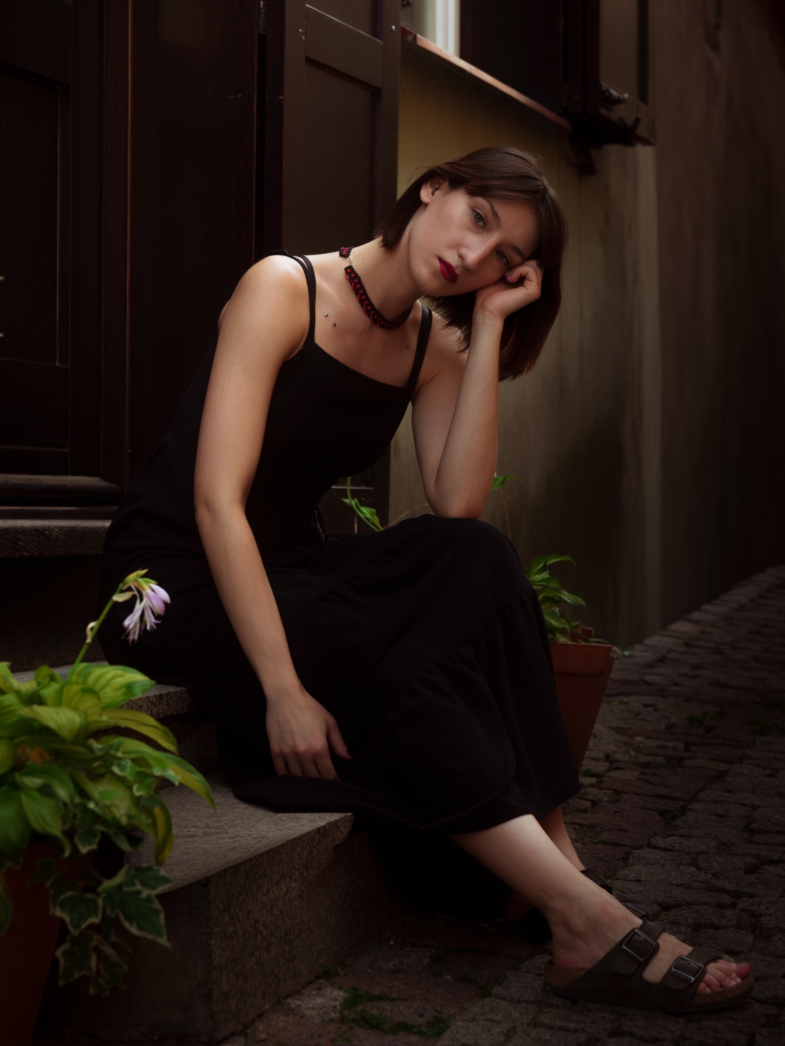 Portret kobiety w czarnej sukience przy wejściu do budynku w Lublinie